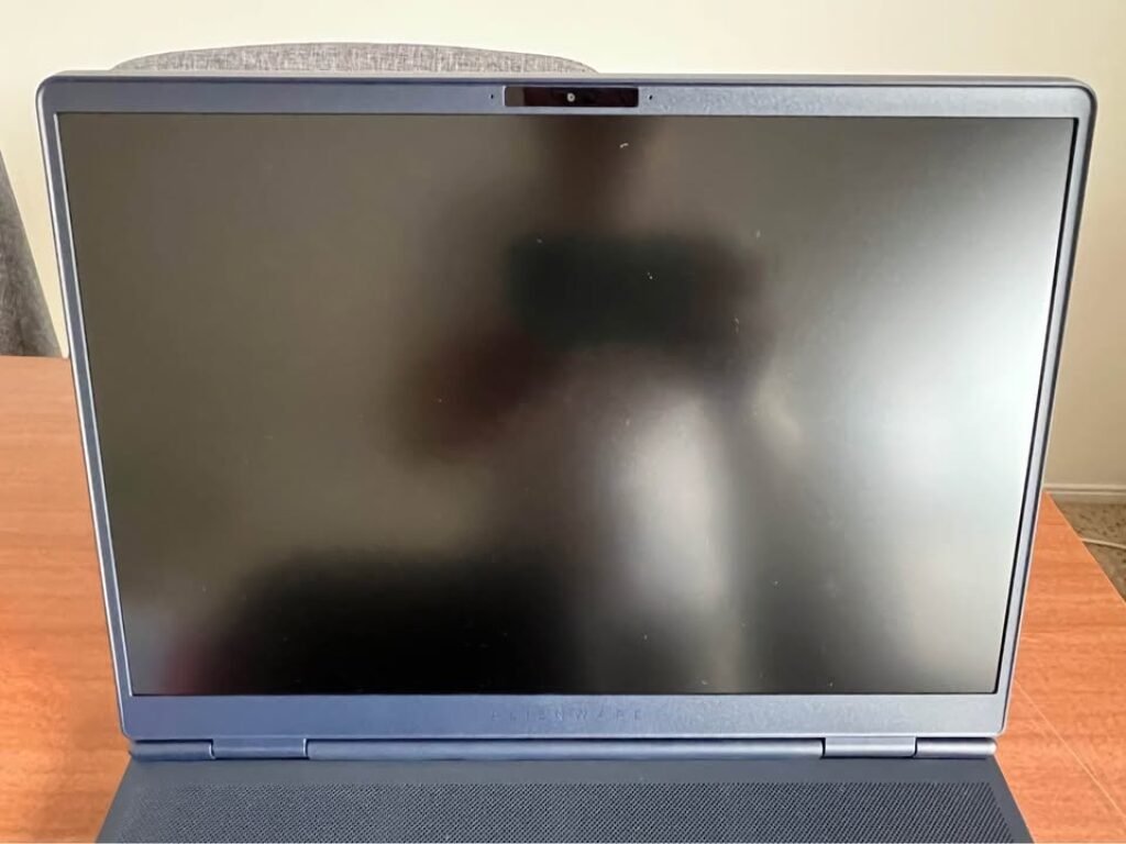 Alienware m16 Aurora Intel Core 7 gaming laptop front display view featuring slim bezels, integrated no-privacy shutter webcam at top center bezel, and speaker grille mesh running along the bottom edge of the display lid