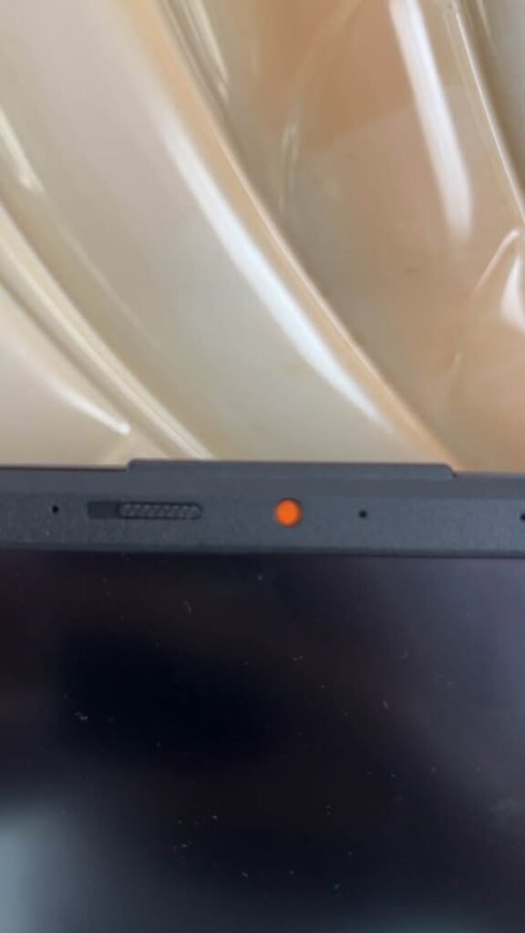 ASUS Vivobook Core i7 laptop top edge view showing the physical privacy webcam shutter activated with orange indicator light turned on
