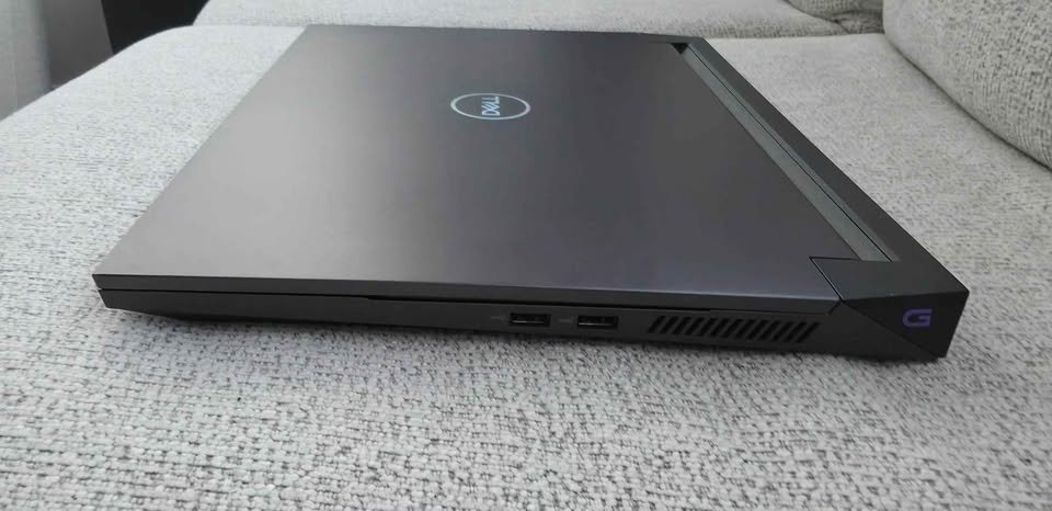 Dell G15 Gaming Laptop Closed Lid Right Side View Showing Dual USB-A Ports Ventilation Grille And Illuminated G Logo