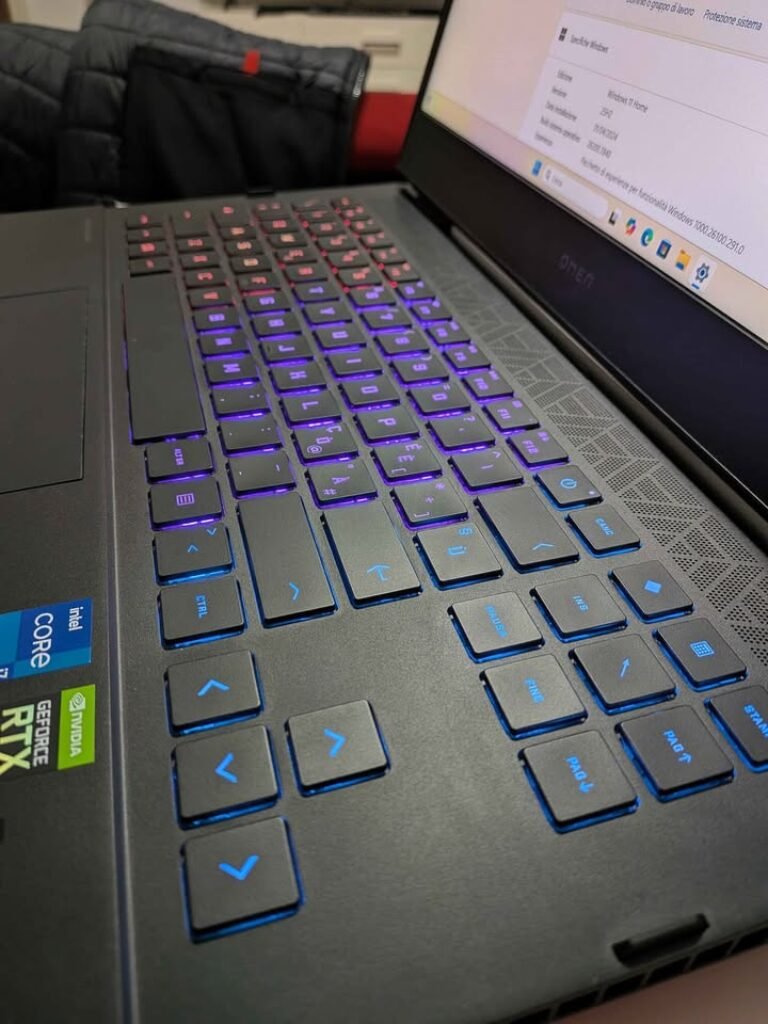 HP Omen 16 gaming laptop with RGB backlit keyboard illuminated in a blue-to-purple gradient, built-in speaker grille, featuring Intel Core i7-14650HX processor