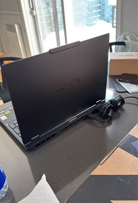 Lenovo Legion 5 gaming laptop with AMD Ryzen 7 processor and NVIDIA RTX GPU — rear lid-open view highlighting dual rear exhaust ventilation grilles, reinforced dual-hinge mechanism and USB Ports.