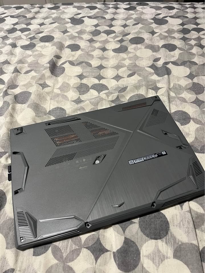 MSI Katana 15 gaming laptop bottom panel view showcasing dual heat sink copper pipes, ventilation grills, and angular chassis design on Intel Core i7 with NVIDIA RTX GPU